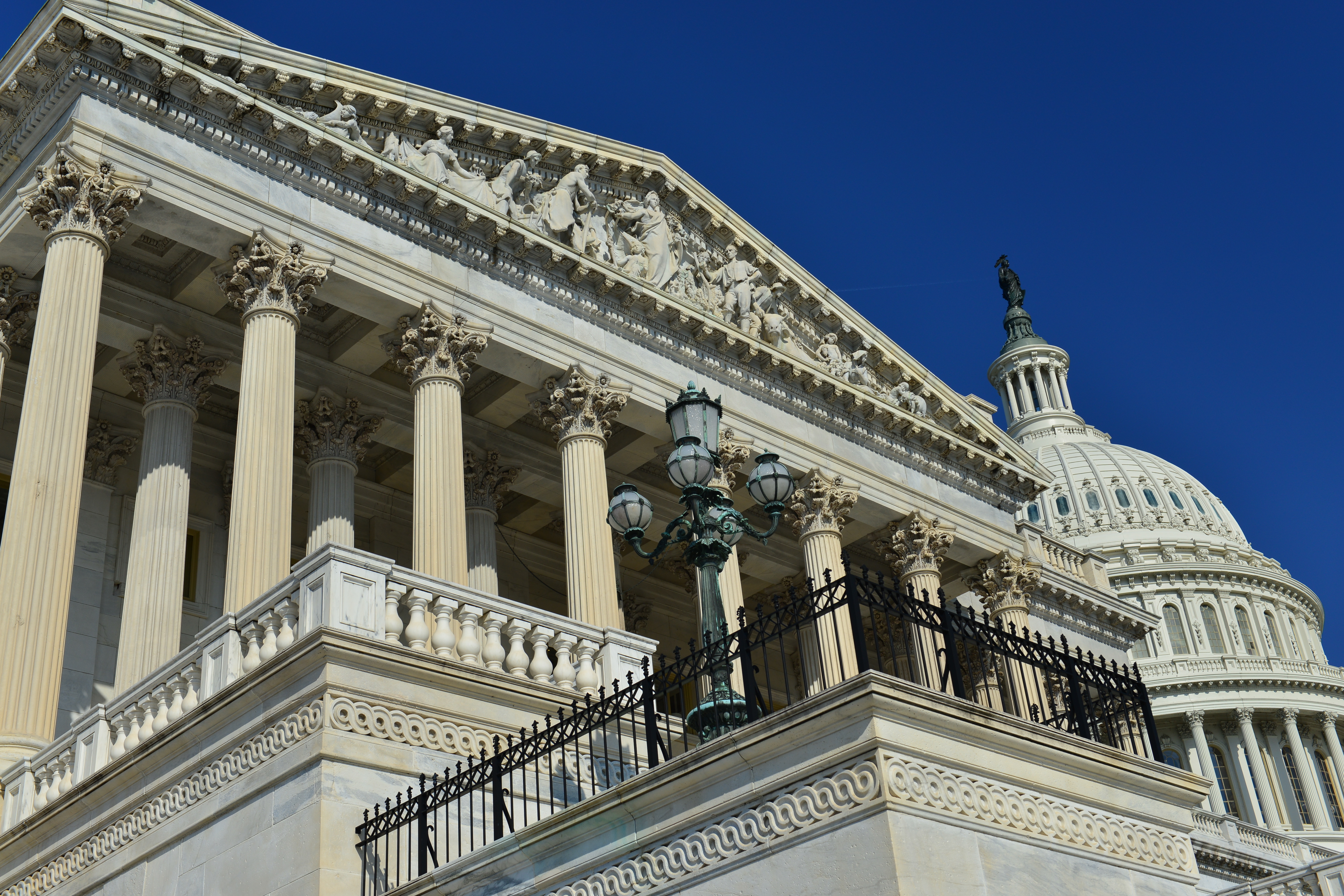 KJ Reports, Global — A low-angle, serious shot of the US Treasury Department building in Washington D.C. under a heavy, overcast sky, representing the weight…