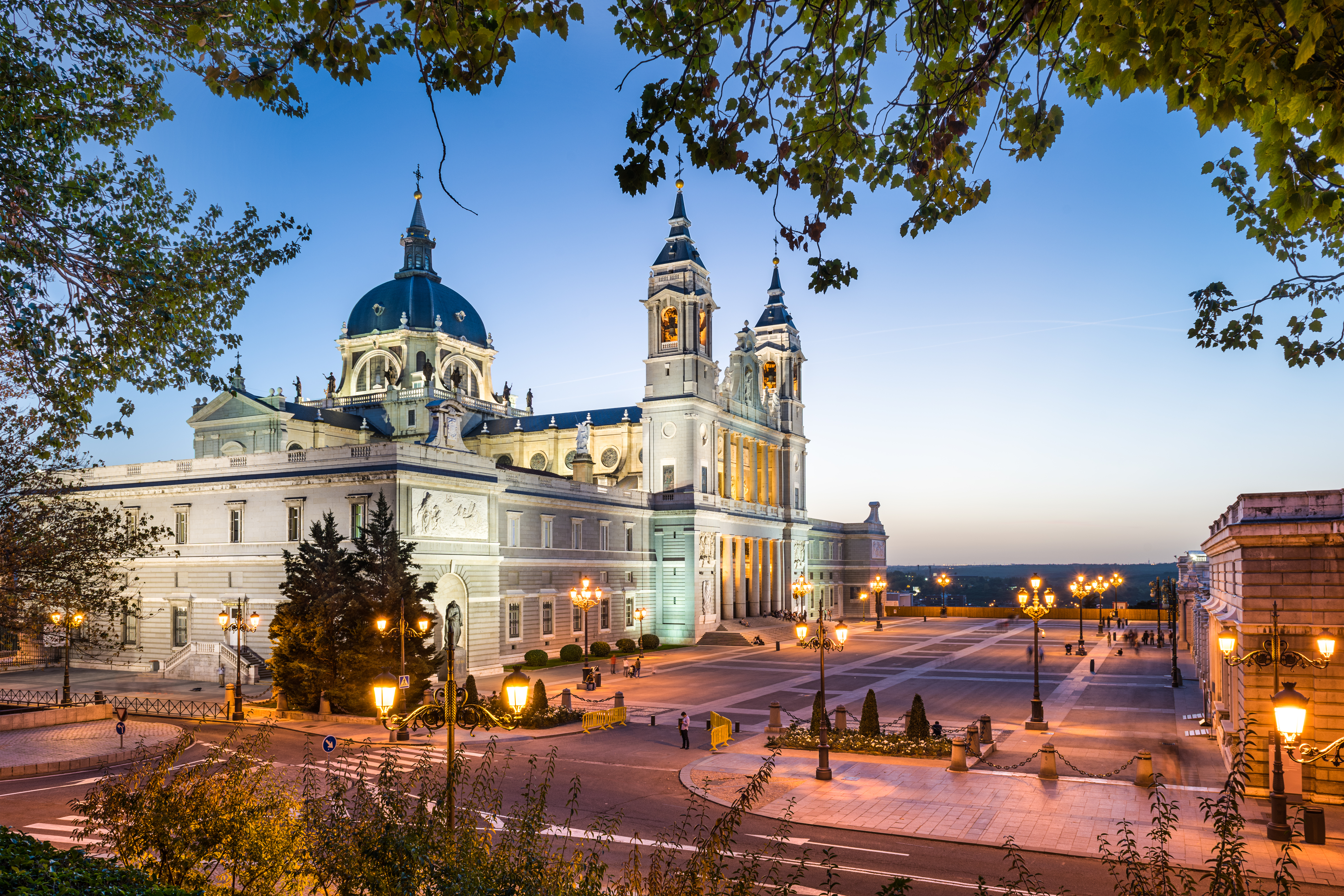 KJ Reports, Global — A wide shot of the Royal Palace of Madrid under a dramatic, cloudy sky, symbolising the weight of sovereign decision-making